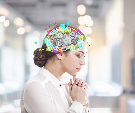 Žena u bijeloj košulji s ilustracijom mozga koji sadrži zupčanike i šarene elemente.