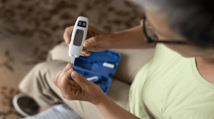 Žena s dijabetesom provjerava razinu glukoze u krvi pomoću glukometra kao dio svakodnevne kontrole šećera.